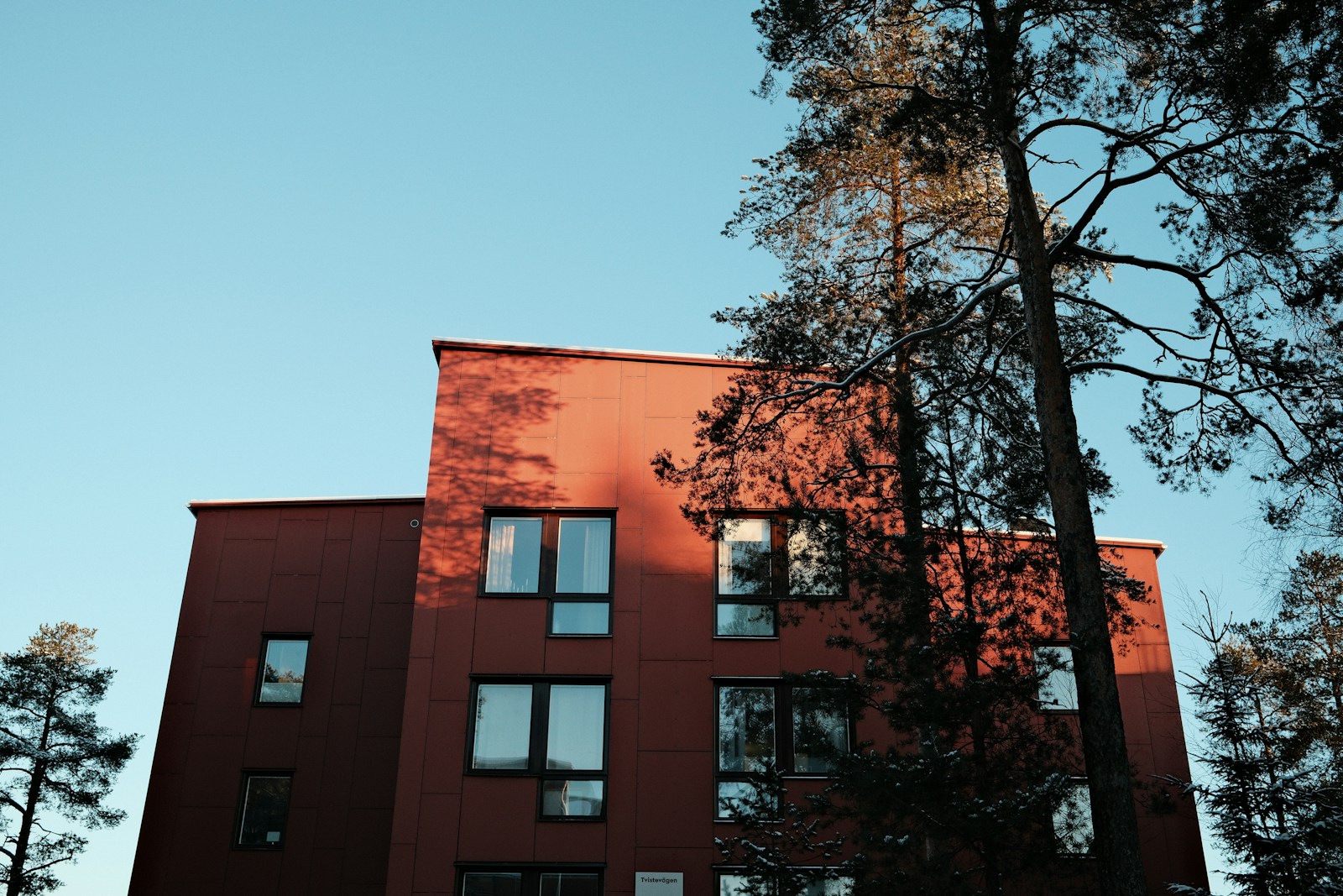 Ett flerbostadshus med träd utanför