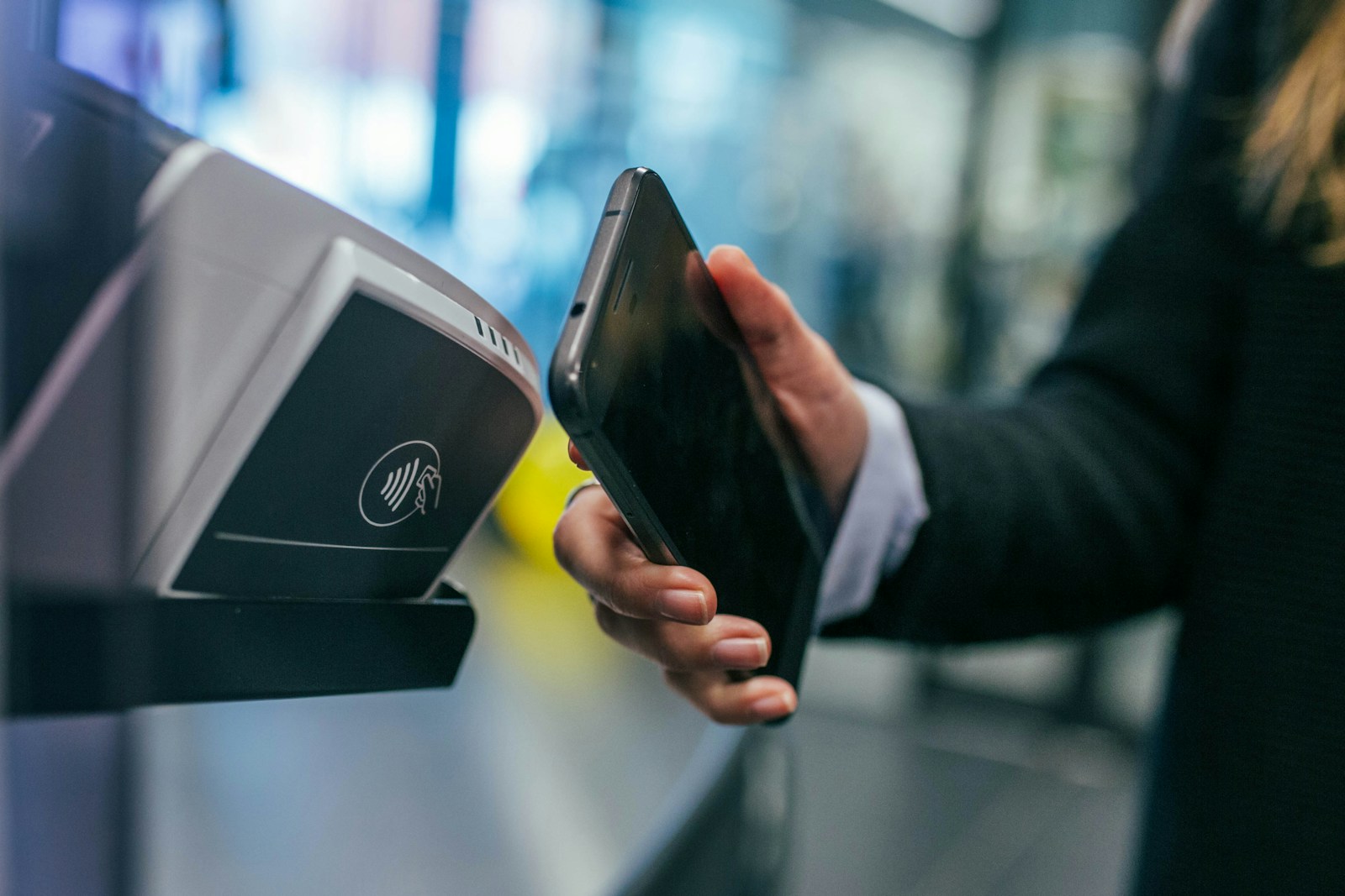 En hand som håller en mobil vid en betalning