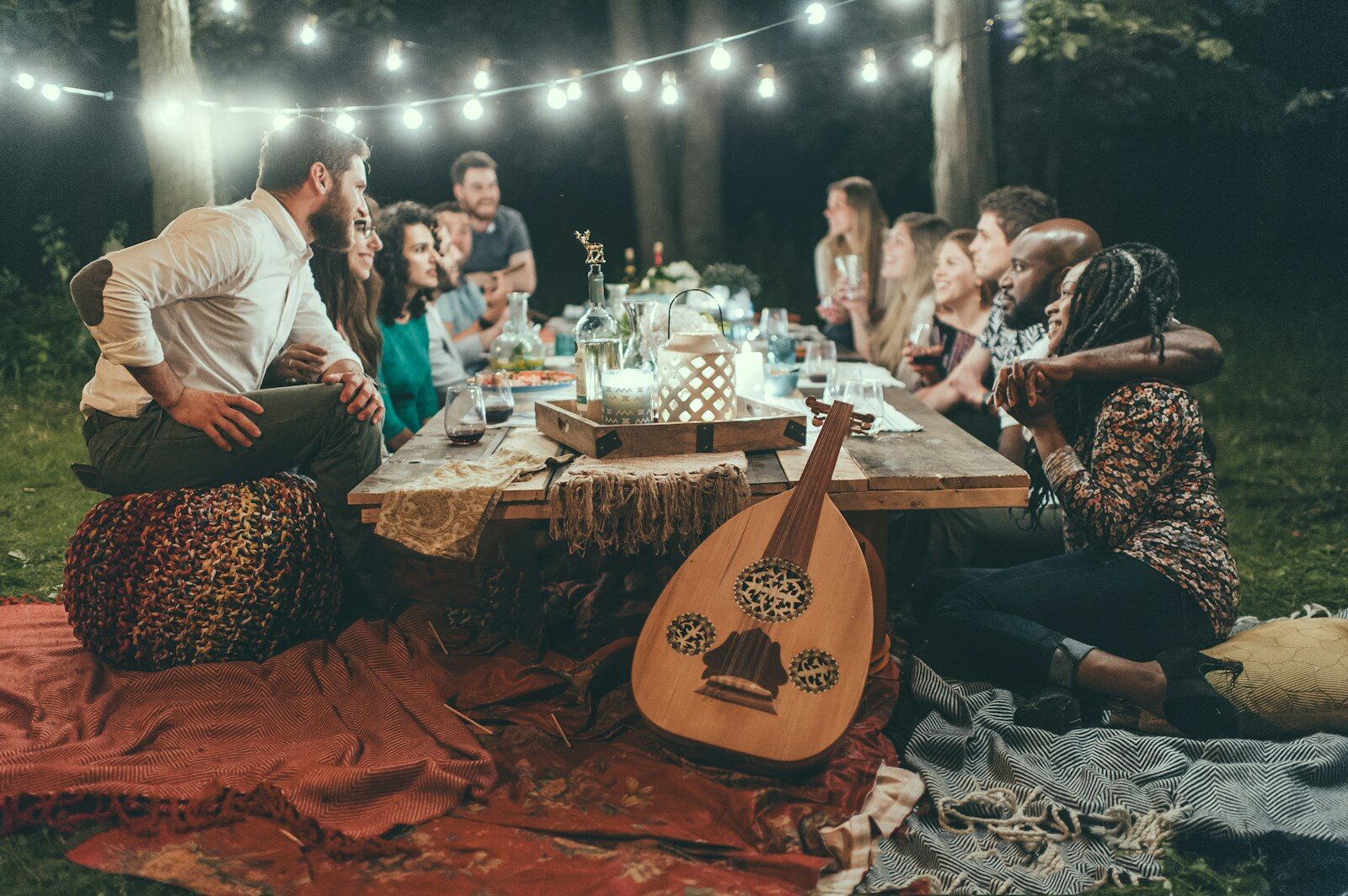 Trädgårdsfest en sommarkväll med ljusslingor och långbord