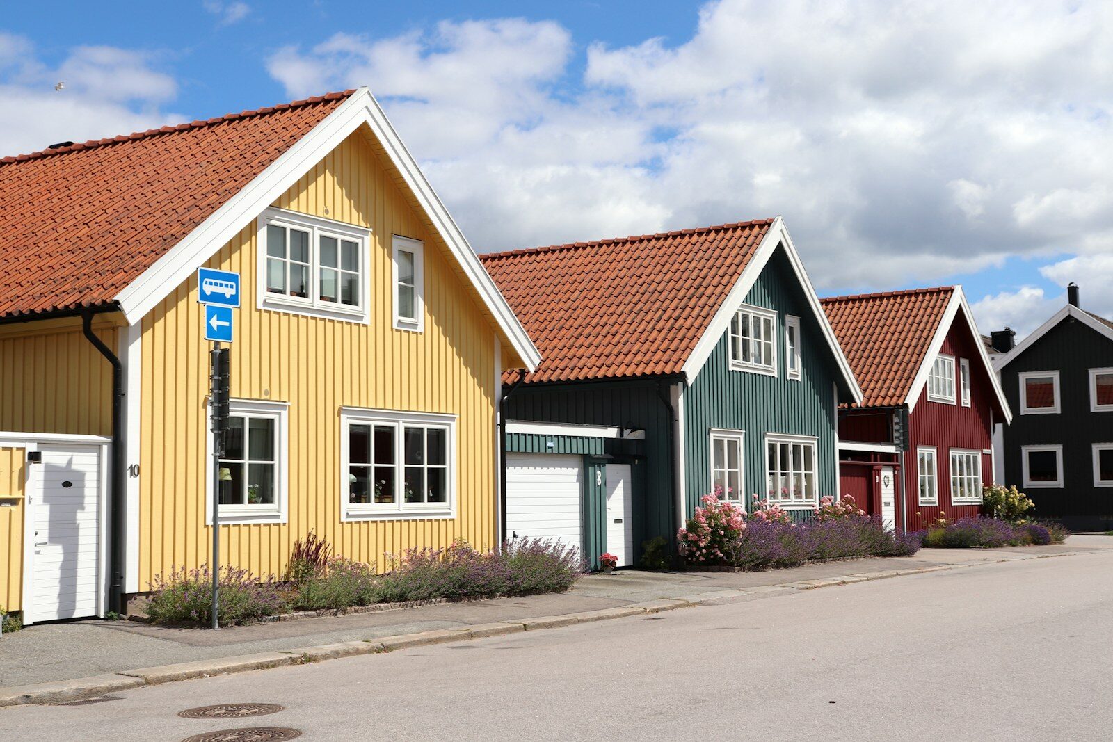 Svenska trähus i gult och rött längs en villagata